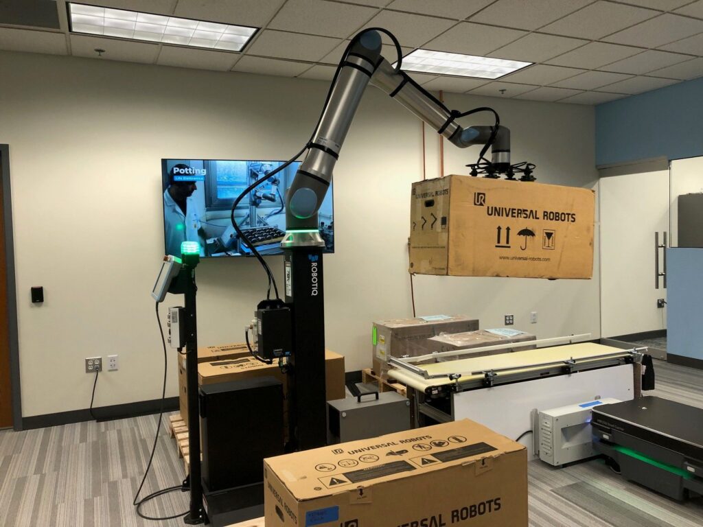 Universal Robots moving boxes from a pallet to a conveyor.